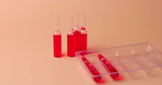 video of b12 injection Vitamin B12 vials, red pills and a loaded syringe with a medical report on cream background for nutritional deficiency treatment
