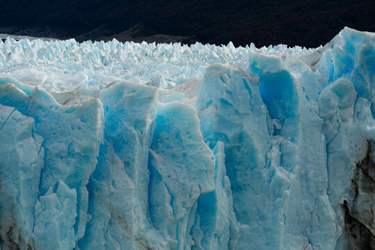 View of the Perito Moreno Glacier's vivid blue ice contrasting with the dark mountains, a majestic landscape, El Calafate, Santa Cruz Province, Argentina.