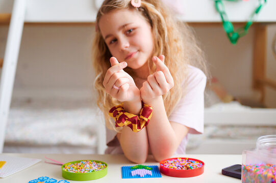 Girl making heart sign for Valentine's Day at table