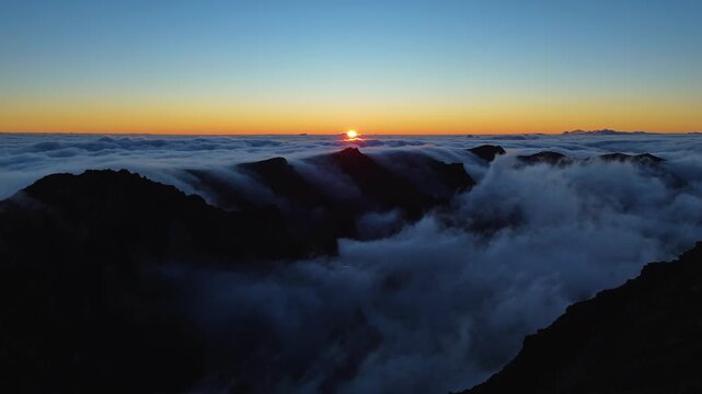 Aerial drone footage of sunrise breaking through clouds in Roque de los Muchachos, La Palma