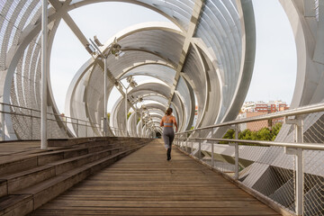 Woman running on modern urban bridge for exercise