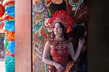 Chinese Lunar New Year with a young woman traditional red dress celebrates Chinese New Year 2026 with intricate headpiece and colorful temple art
