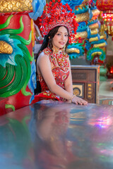Chinese new year 2026 celebration with woman wearing traditional red dress and ornate headdress smiling happily Celebrating lunar new year