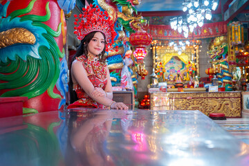 Young woman traditional red dress celebrates Chinese New Year 2026 with vibrant decorations and joyful spirit temple Celebrating lunar new year
