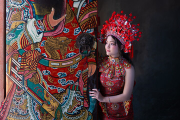 Portrait of a young woman and elaborate headdress celebrating Chinese New Year 2026 standing by colorful painted Celebrating lunar new year