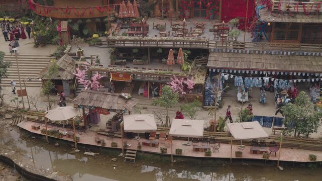 Atmospheric view of Cat Cat Village in Sapa, Vietnam, featuring traditional houses, greenery, riverside and a waterfalls setting that reflects the peaceful mountain village environment.