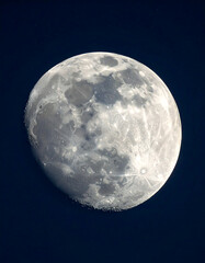 Waning gibbous moon, craters visible on surface, isolated against a dark blue night sky