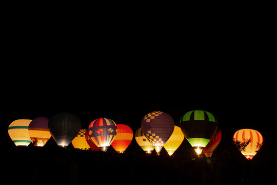 Illuminated hot air balloons in forest at night
