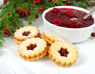 Holiday cookies with jam filling beside cranberry sauce, evergreen branch