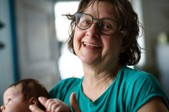 Portrait of happy senior woman with grandson at home