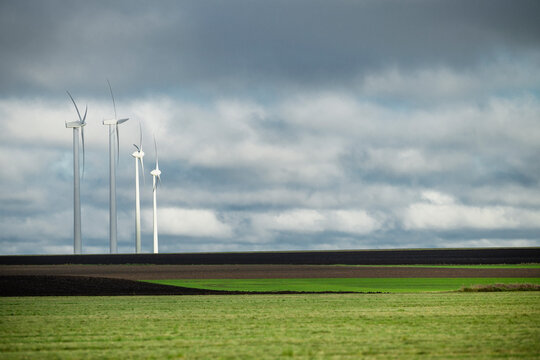 Wind turbines in row against cloudy sky