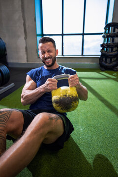 Determined athlete exercising with kettle bell at health club