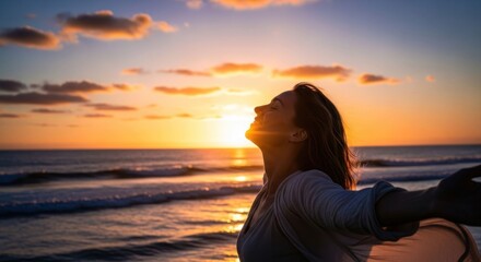 Woman embraces sunset by the ocean, arms outstretched, feeling free