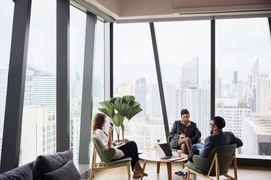 Team of young corporate professionals discussing in team meeting at office