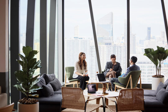 Young female entrepreneurs sitting with male manager in office