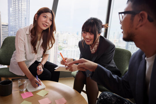 Group of smiling entrepreneurs discussing business strategies at office