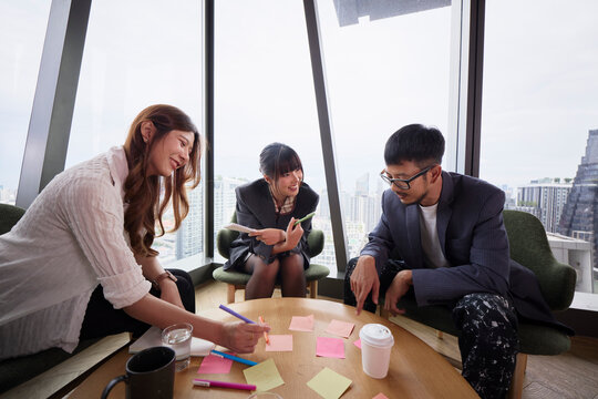 Group of male and female entrepreneurs discussing ideas while sitting around table
