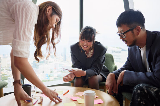 Businesswoman assisting coworkers while planning strategies at office