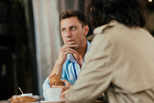 Coworker listening intently during coffee break at cafe