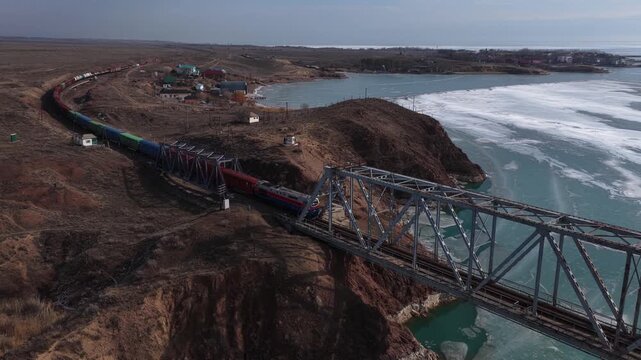 Almaty, Kazakhstan - 02.10.2026 : The train travels over the old iron bridge over the Kapchagai reservoir. 