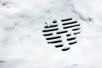 Partially snow-covered manhole with patterned grate &mdash; ideal for urban hazard awareness, municipal safety and aesthetic infrastructure documentation