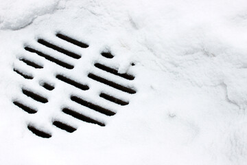 Snow-covered manhole cover with grated surface &mdash; ideal for municipal safety, winter infrastructure inspection and urban hazard documentation