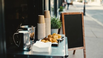 Takeaway cups and pastries with blank chalkboard sign