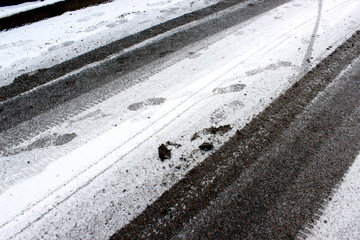 Tire and footprints on snowy courtyard asphalt &mdash; ideal for urban infrastructure, winter maintenance and residential safety documentation.