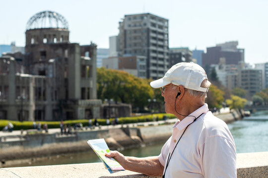 Senior man holding map while exploring city on vacation