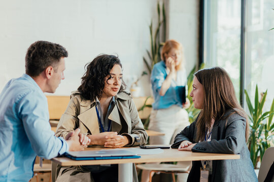 Diverse coworkers collaborating during office coffee break discussion