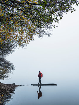 Man walking on jetty by lake