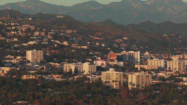 Telephoto aerial panning shot of West Hollywood as seen from Beverly Hills at sunset in Los Angeles, California. 4K