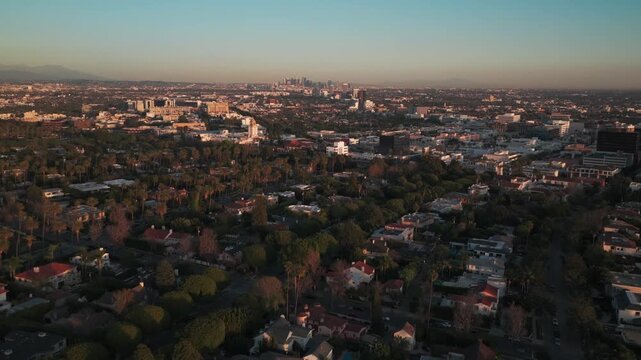 Aerial low tilting-up shot of downtown Beverly Hills at sunset in Southern California. 4K