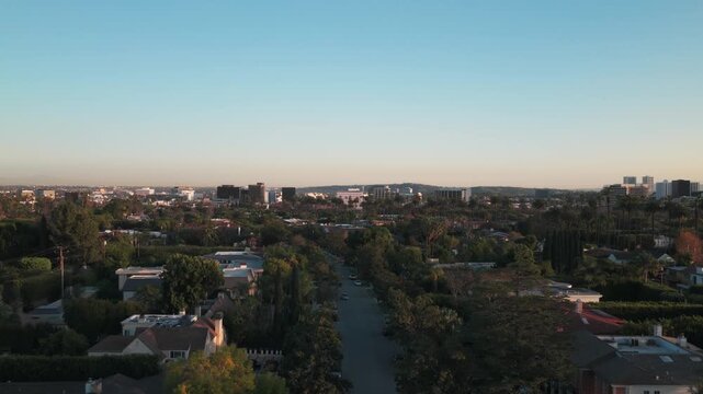 Aerial low rising shot of downtown Beverly Hills at sunset in Southern California. 4K