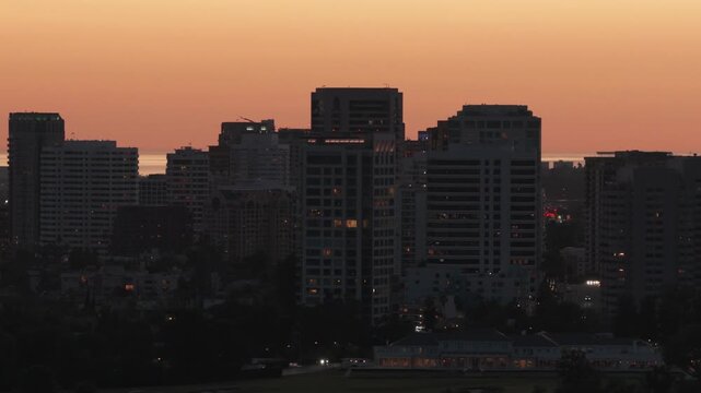 Telephoto aerial dolly shot of West Los Angeles at twilight in Southern California. 4K
