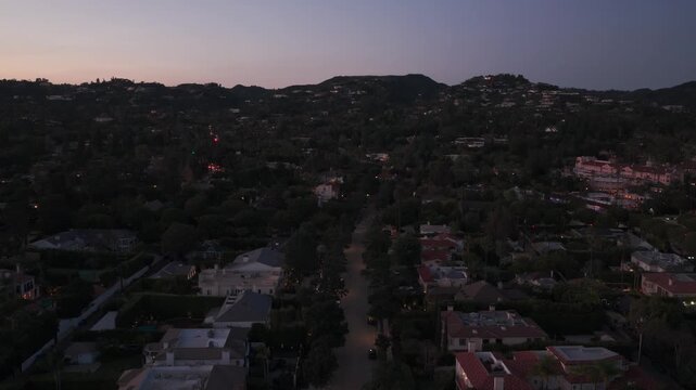 Low aerial shot flying over mansions and estates in Beverly Hills at twilight in Southern California. 4K