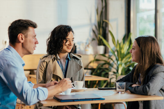 Business coworkers discussing during coffee break in cafe