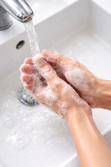 Fototapeta premium Hands washing with soap and running water in a sink