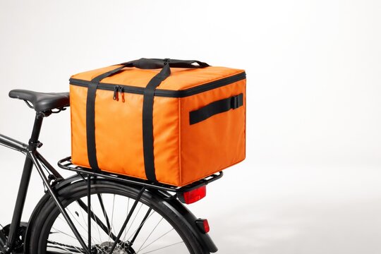 Orange insulated delivery bag attached to the rear rack of a bicycle