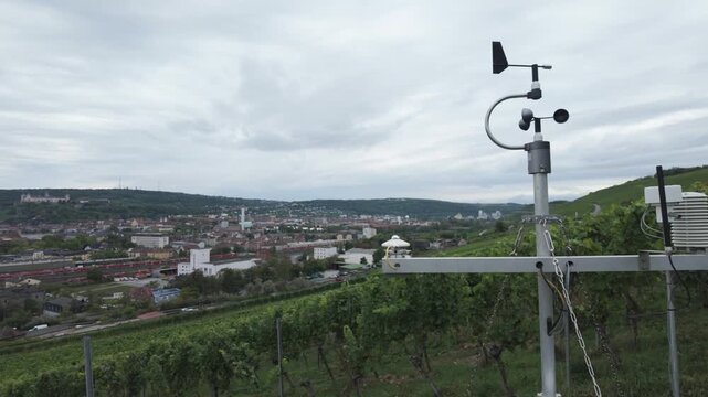 Weather station with cup anemometer, wind vane, thermometer and humidity sensor on a vineyard. Smart farming technology, measuring meteorological conditions. Air quality and climate monitoring.
