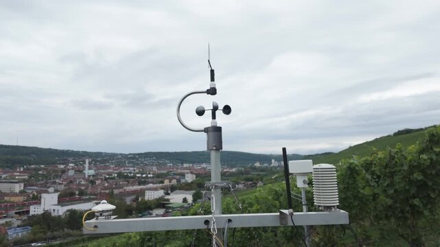 Weather station with cup anemometer, wind vane, thermometer and humidity sensor on a vineyard. Smart farming technology, measuring meteorological conditions. Air quality and climate monitoring.