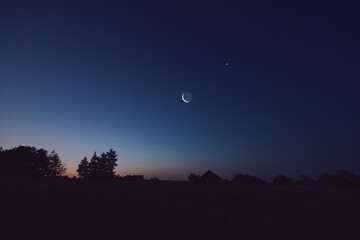 Morning old Moon with stars, planets and rural countryside tree silhouettes. © astrosystem