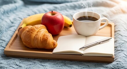 Comforting breakfast tray with a steaming coffee, croissant, apple, banana, and an open notebook with pen.