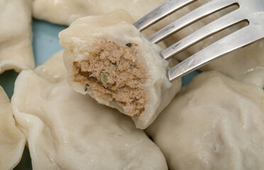 Delicious traditional homemade Polish pierogi stuffed with meat, close-up of a cut pierogi stuffed with meat