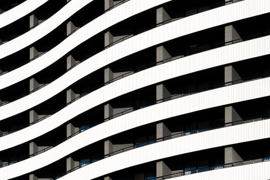 Striking monochrome wavy apartment balconies in Spain creating graphic architectural rhythm and bold abstract facade pattern background