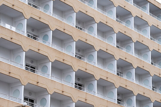 Architectural balcony repetition on a Spanish residential building facade with sculpted zigzag edges creating abstract apartment pattern in Spain