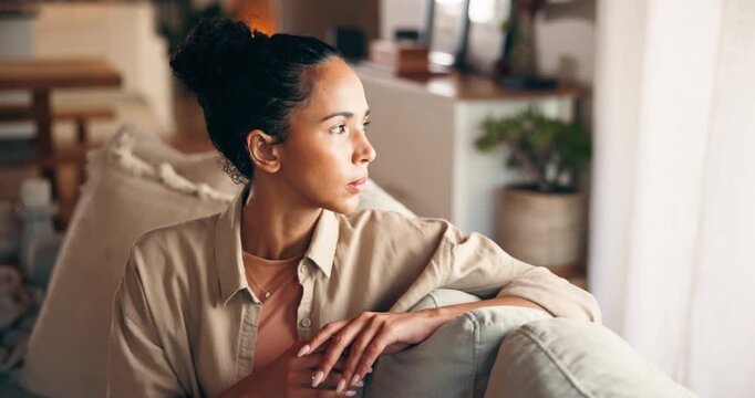 Sad, thinking and woman in home with stress, worry or loneliness with broken heart in living room. Lost in thoughts, reflection and person with anxiety, depression or memory for breakup on sofa