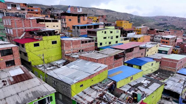 Steep High Angle View from Ascending TransMiCable Cable Car Over Dense, Colorful Slum Housing and Rooftops in Ciudad Bolivar, Bogota, Colombia.