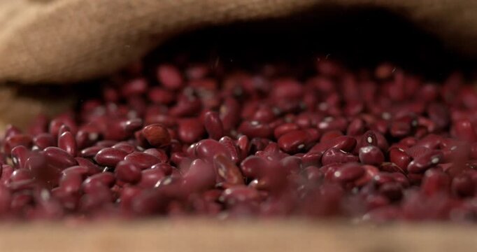 Slow Motion, Creative Shot Capturing Glossy Adzuki Seeds Gently Pouring Onto Woven Natural Fiber Fabric