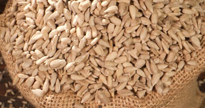 Burlap Bag With Seeds. Farmstyle Presentation Of Sunflower Seeds In Coarse Jute Sack Under Warm Lighting